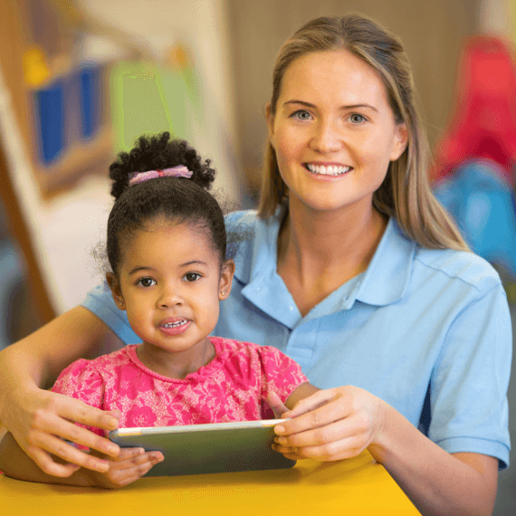 Woman and child looking at camera with a computer tablet